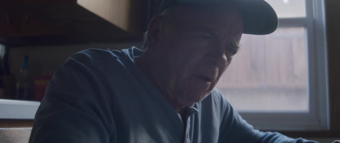 An elderly man looks confused and scared as he looks at a tablet