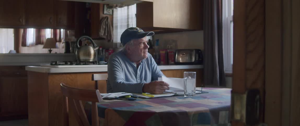 Elderly man sitting at a table looking through some documents
