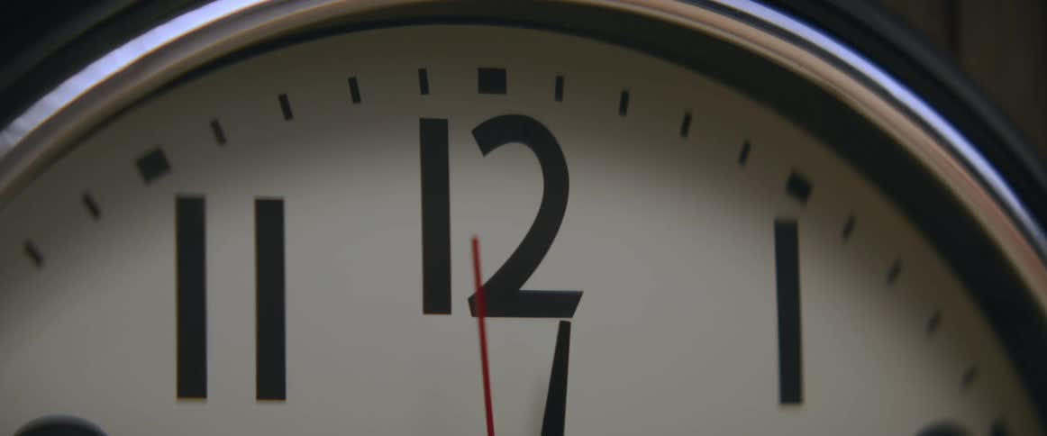A closeup of a clock face with the numbers 12 and 1 prominently displayed