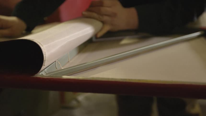 A person rolls back a fabric surface