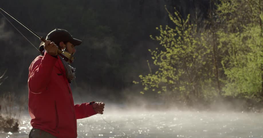 A fisherman casts his line into the water