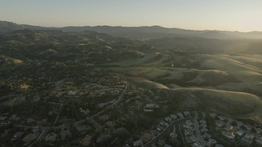Aerial view of suburbs and the green land beyond them