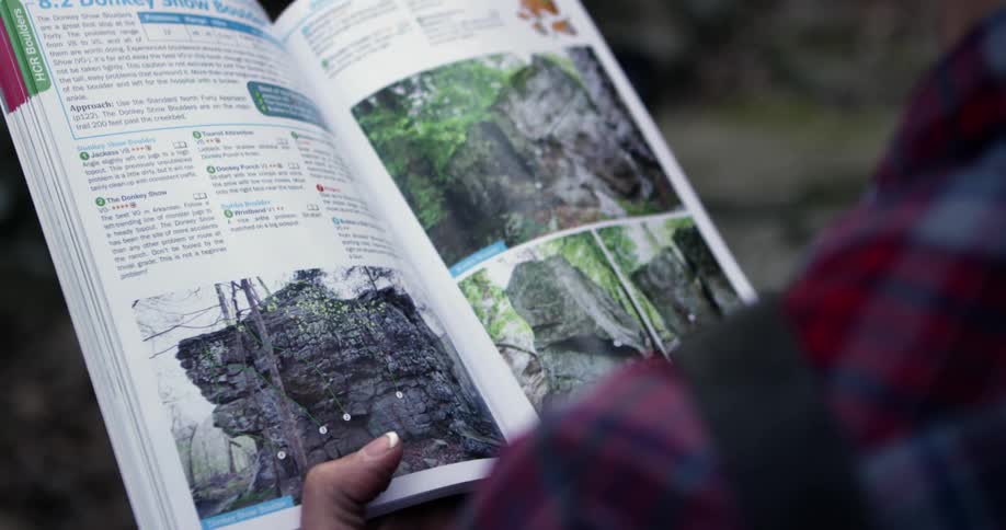 A person is reading a hiking guidebook