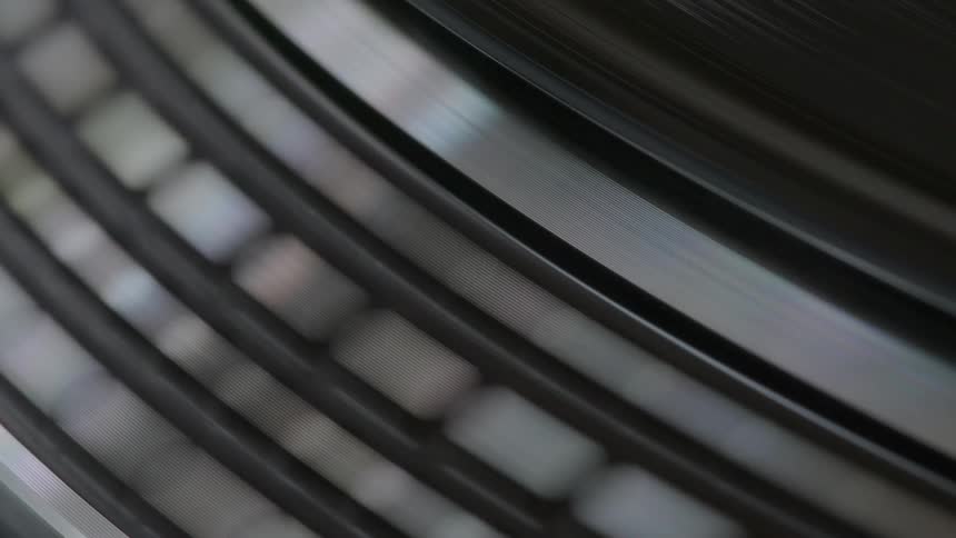 Spinning metal disk with a rim containing a raised pattern stops moving