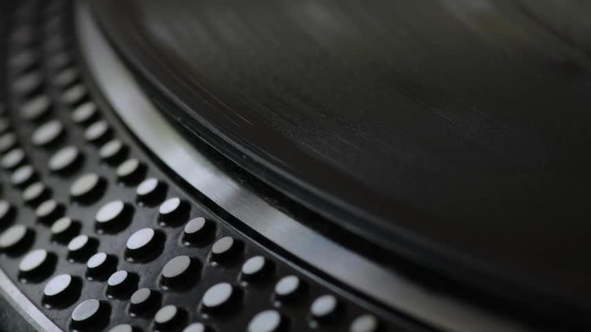 A closeup of a vinyl record spinning on a turntable