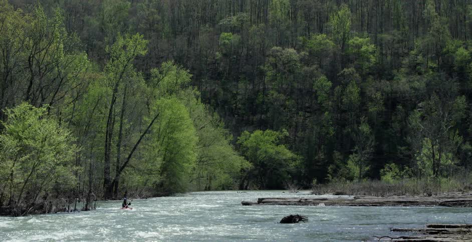 Person kayaking down a large river