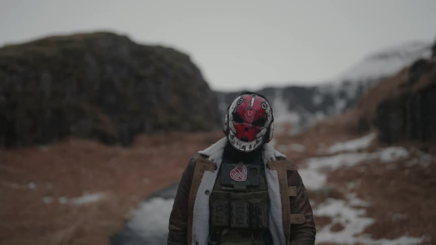 Person wearing a skull mask walking through a natural area