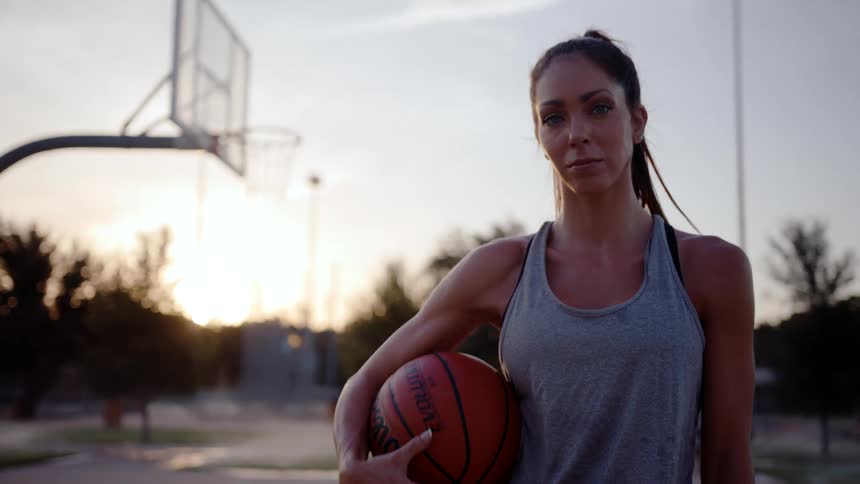 Woman on a court holding a basketball