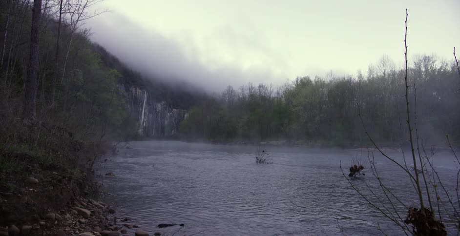 Fog lifts from a flowing river