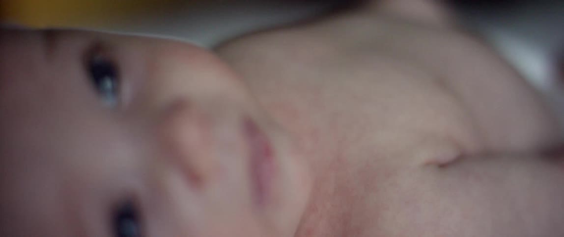A little baby is lying on its back looking up