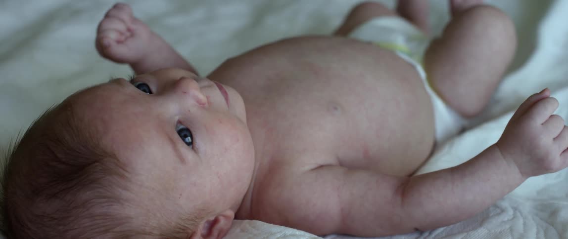 Infant looking around while it's lying on its back and wriggling