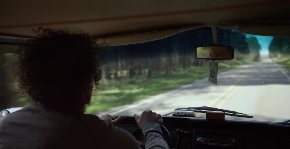 A man taps on a steering wheel while driving