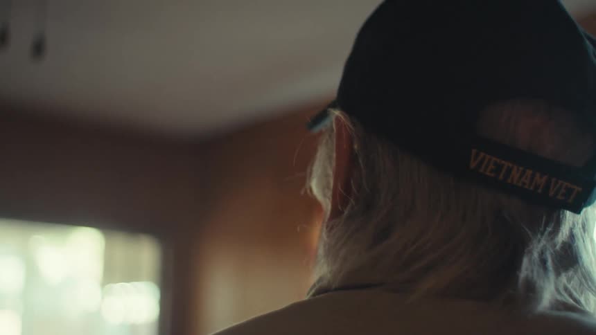 Old man turns around in a dated room while contemplating