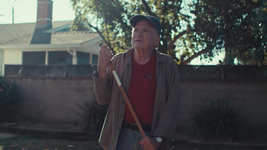 Elderly man cleaning a yard