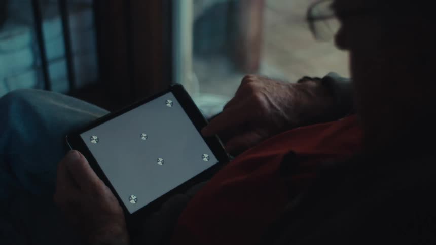 A clip of an elderly man operating a tablet