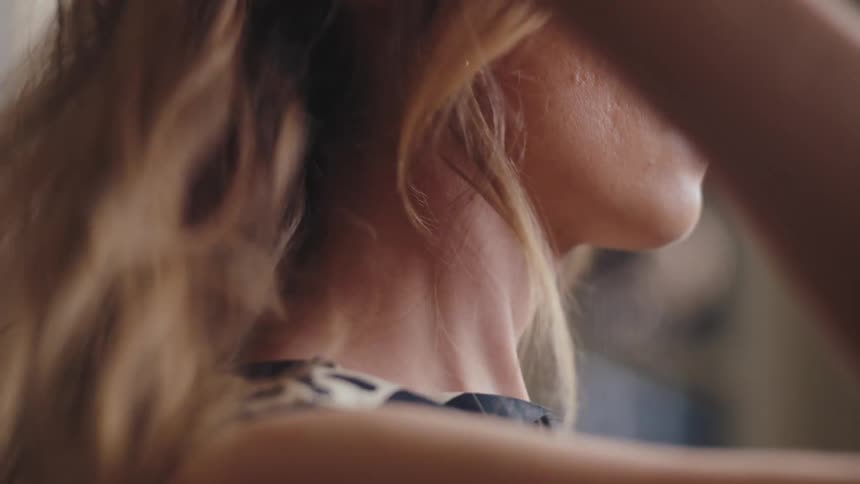 Side portrait of a woman letting down her blonde hair