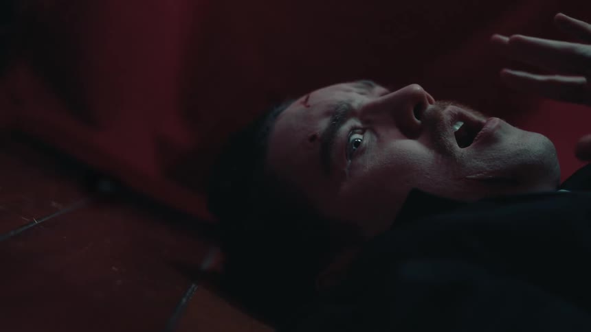 A man with wounds on his face suddenly clenches in fear