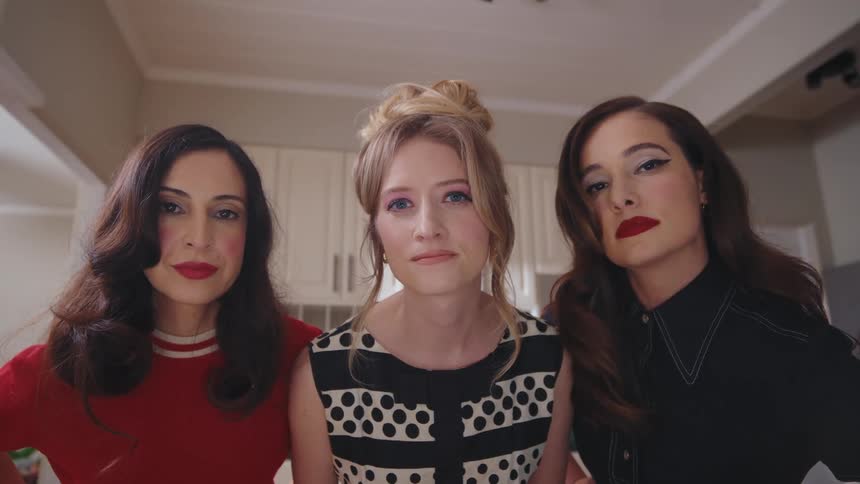 Portrait of three women one blonde and two brunettes wearing red lipstick
