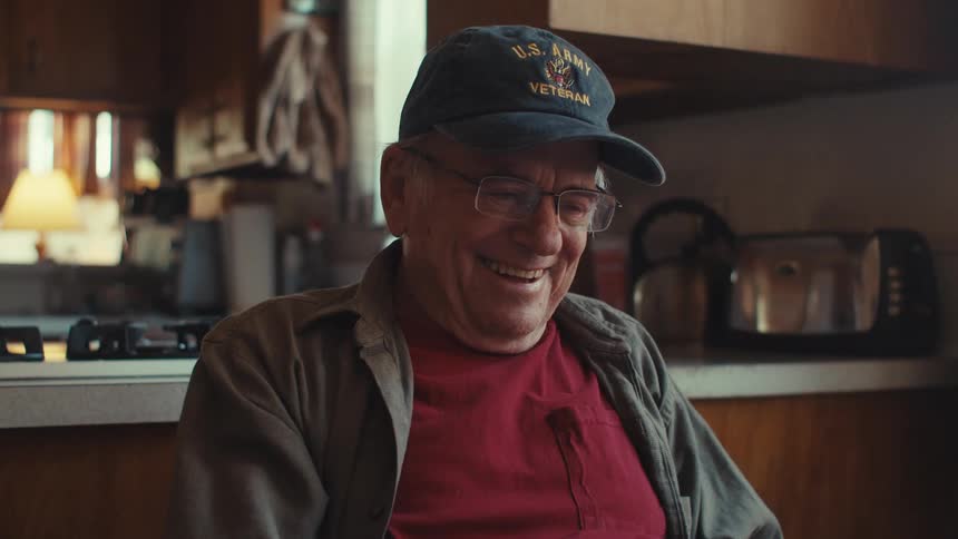 Elderly man sitting and laughing
