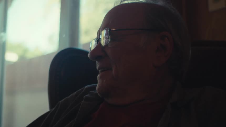 A man is smiling while sitting at home
