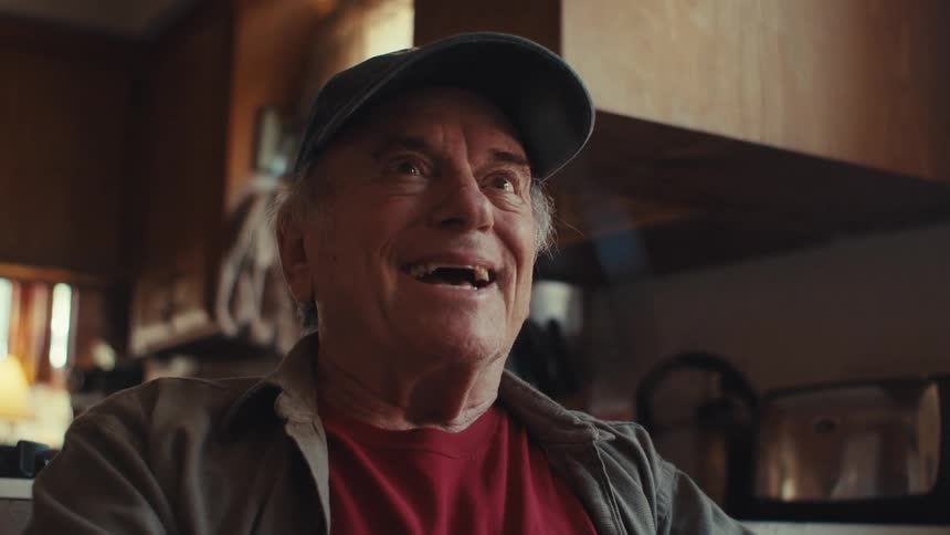 Elderly man sitting talking and genuinely happy