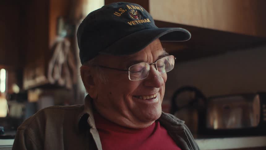Elderly man sitting and being genuinely happy