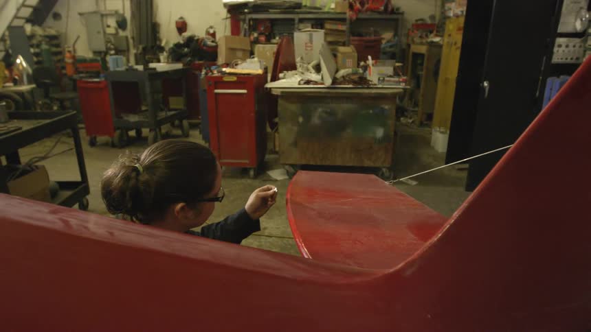 Woman working on a curved surface in a workshop
