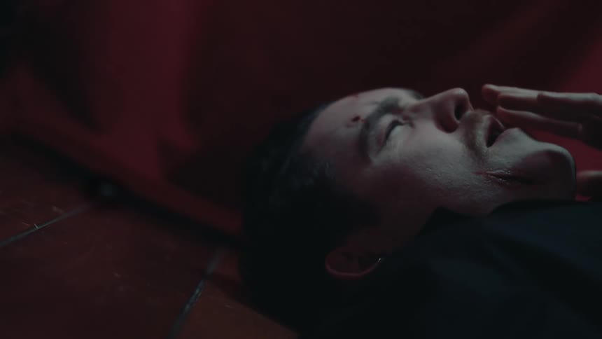 Man lying down putting his hand to his face in pain and bleeding