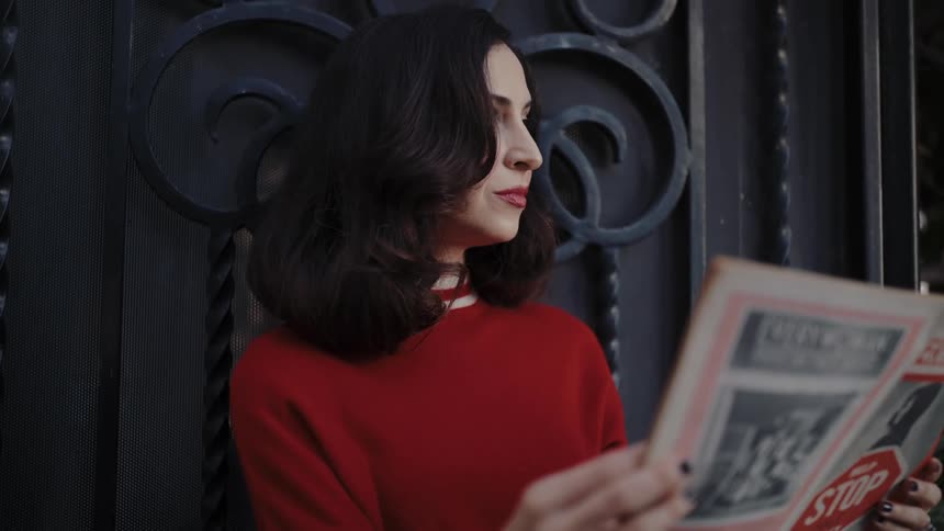 A woman stands outdoors while reading a copy of everywoman magazine