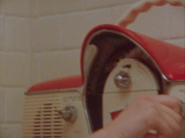 Blonde woman setting up an old radio