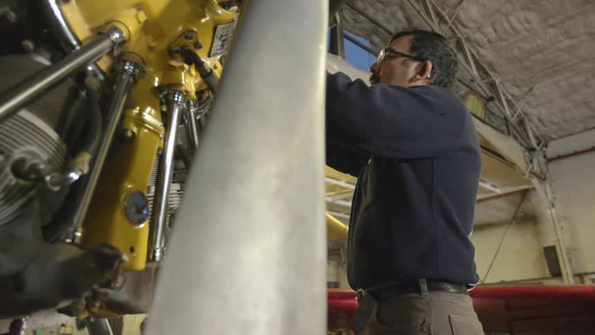 A man inspects yellow machinery