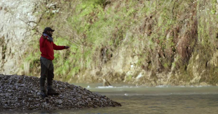 A man casting a fishing rod into a river