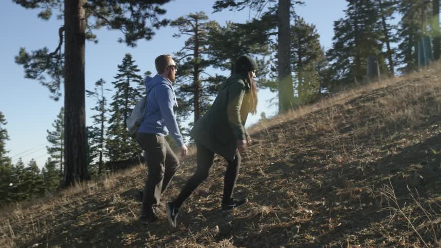 A man and woman walk up a hill