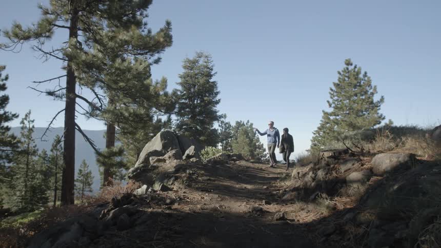 A man and woman walk along a dirt trail
