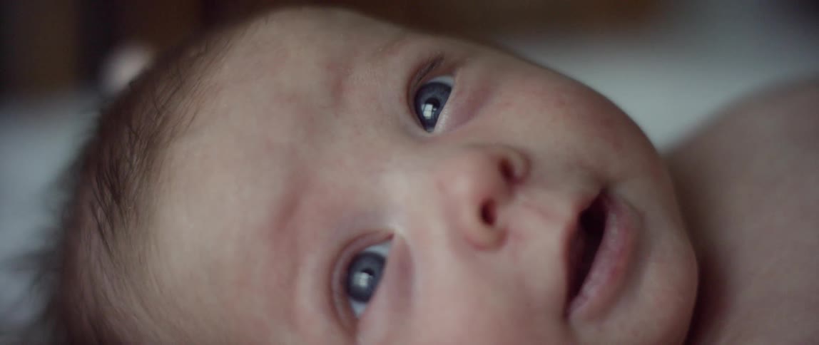 A baby's blue eyes stare up at something