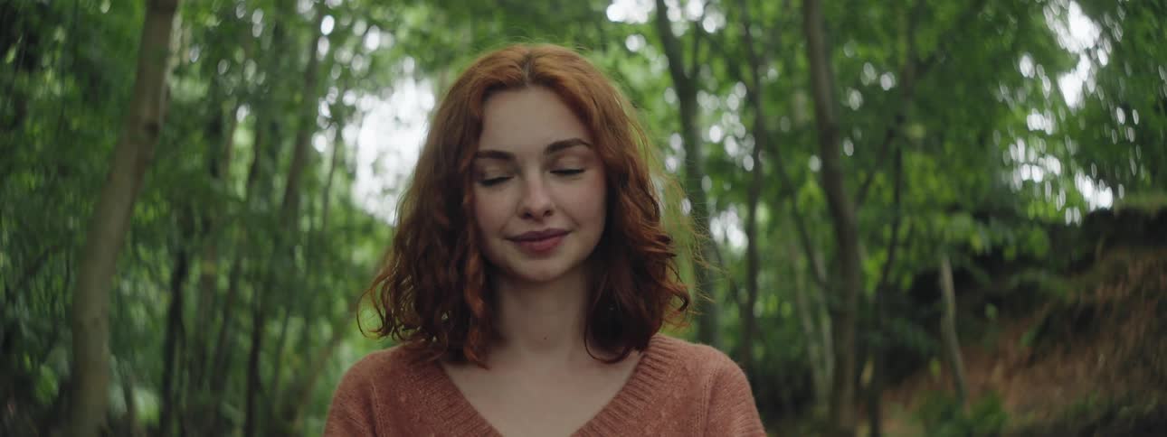 Portrait of a redhaired woman in a dense forest