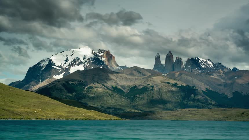The clouds flow over the peaks of the mountains