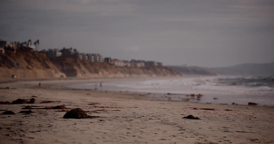Landscape of a beach with a long stretch of sand on a cloudy day