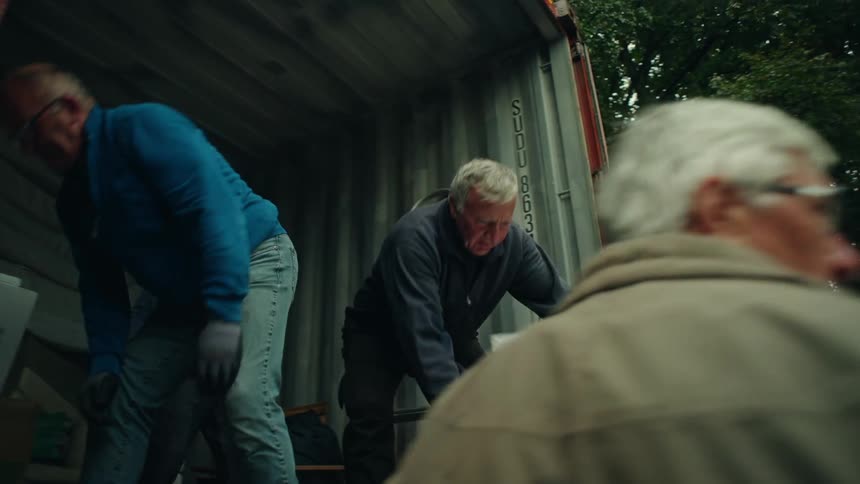 Group of men loading moving boxes into a truck