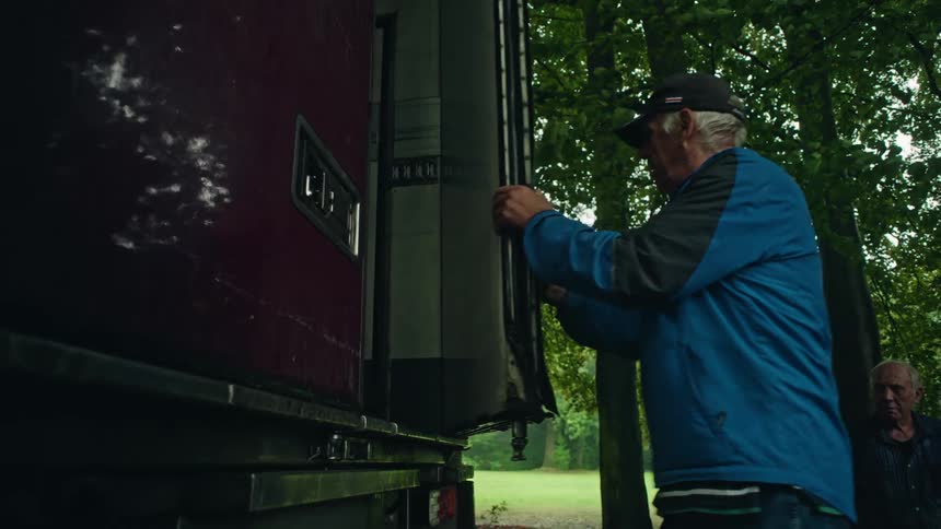 Elderly man opening the trunk of a truck