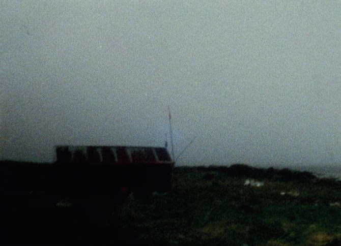 Shed with a rusty roof stands under an overcast sky