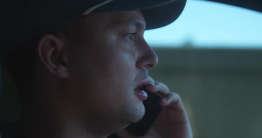 Man talks on the phone while driving outside a city