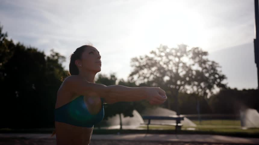 A woman is making bumps on a volleyball with her arms