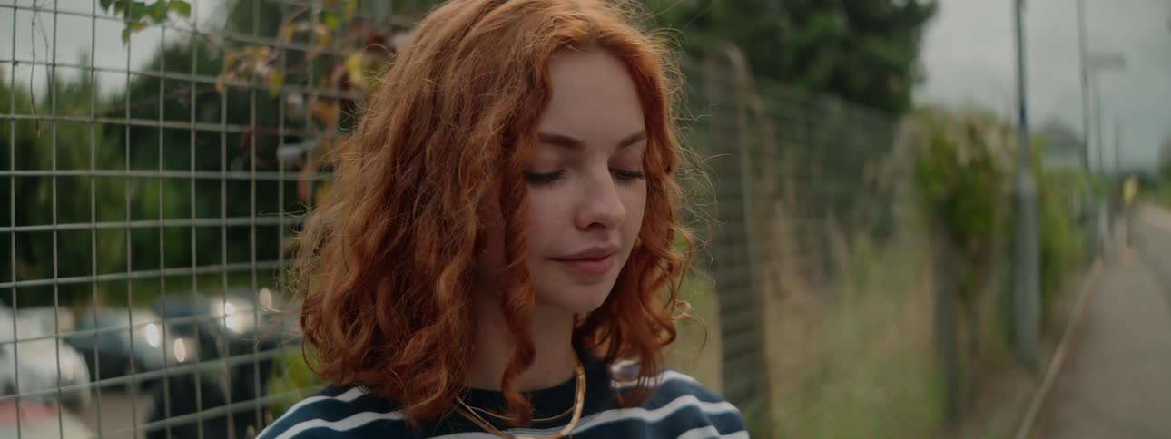 Portrait of a young redhaired woman in an outdoor space