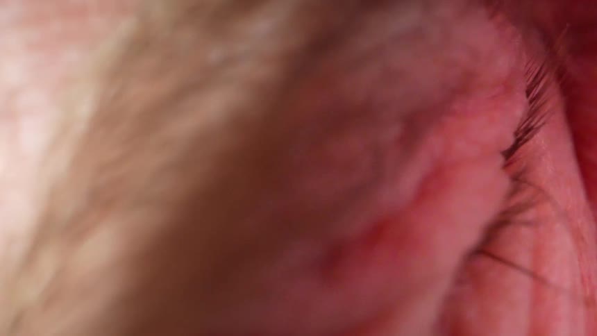 Closeup of eye opening to reveal reflected images