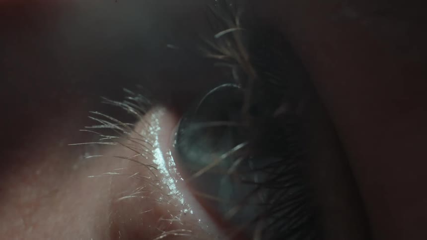 Extreme close up of a persons eye and a reflection of light