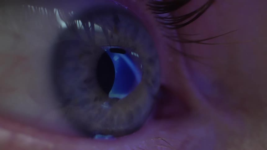 Extreme close up of a persons eye with reflection of lights