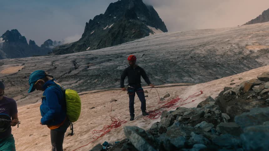 A group of climbers prepare ropes to ascend a glacier