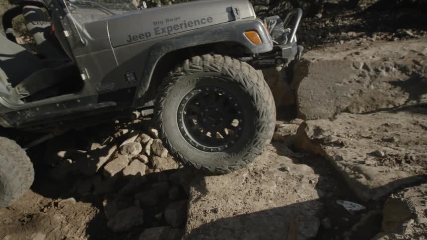 A jeep climbs boulders