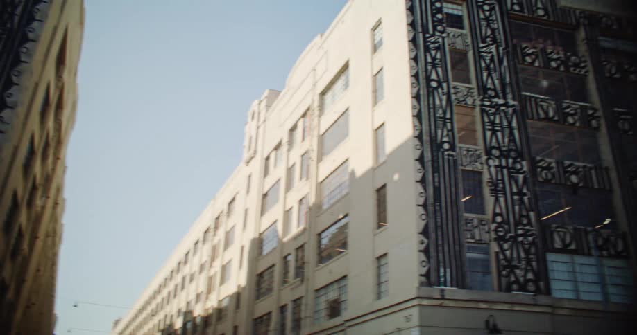 Two tall buildings with intricate designs on their facades stand side by side